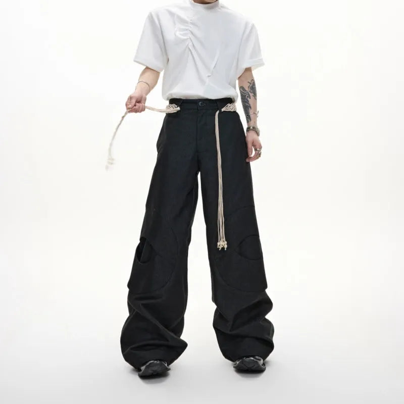 Men's dark blue loose-fit straight-leg cotton trousers with zipper decoration and tassel detail.