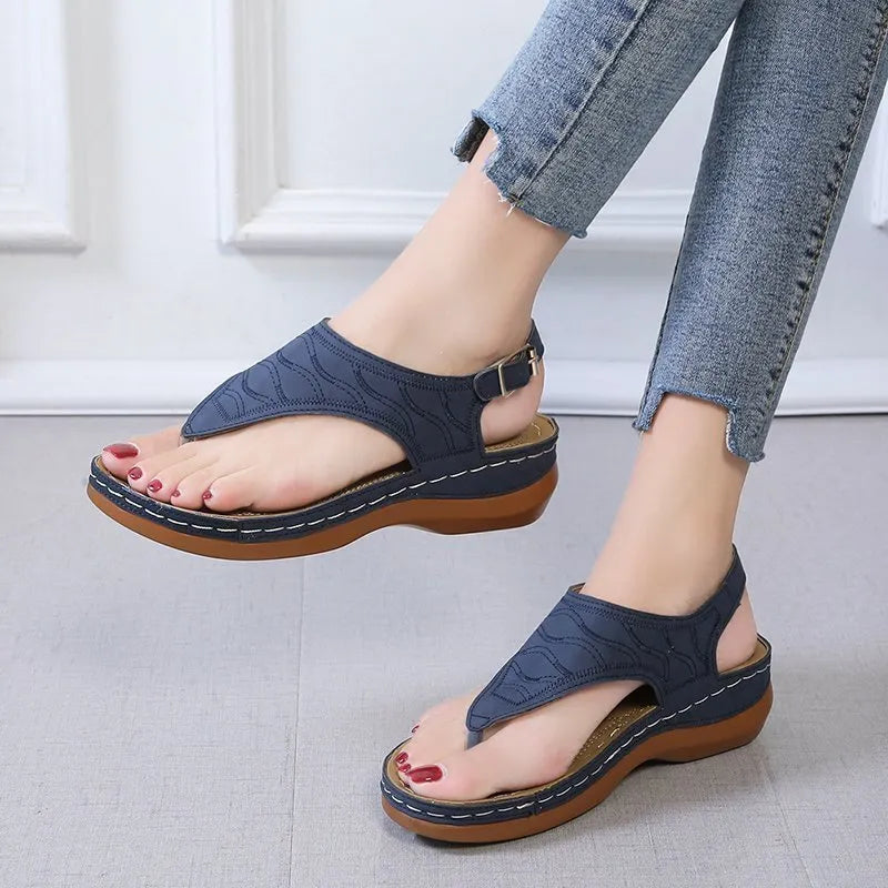 Women's wedge heel flip flop sandals in black with an adjustable back strap and buckle.