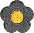 Flower-shaped blue silicone pet lick mat with suction cups on a smooth surface