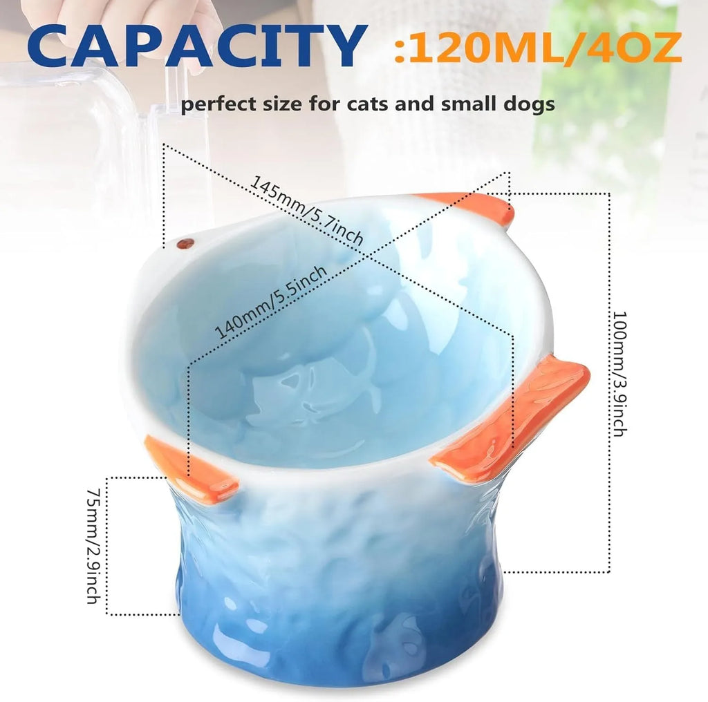 Blue fish-shaped ceramic cat bowl with tilted angle and elevated sides on a white background.