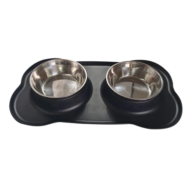 Large black silicone dog bowl sitting inside a stainless steel base, shown on a kitchen floor.