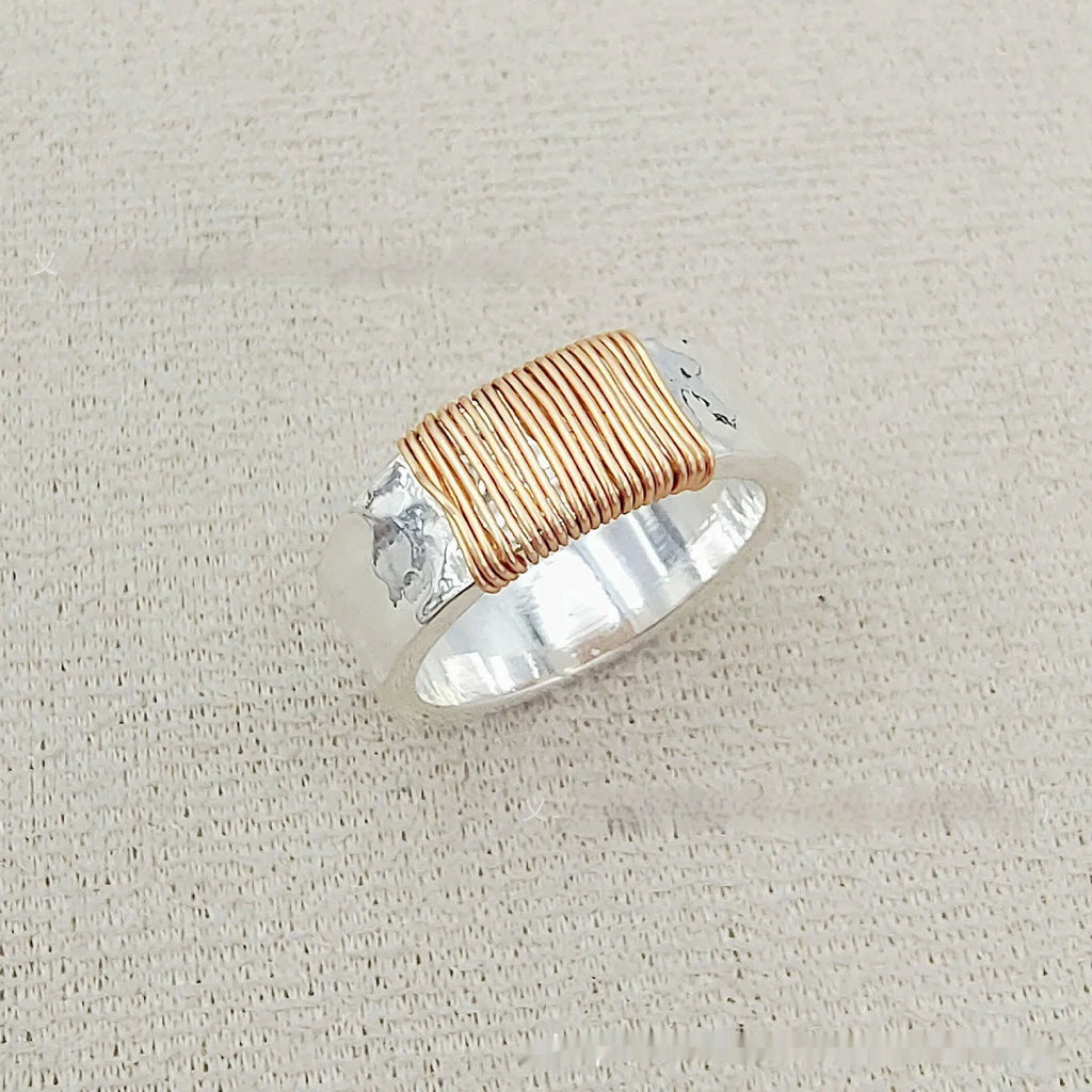 Geometric copper bracelet with irregular coil design and silver-gold electroplated finish.