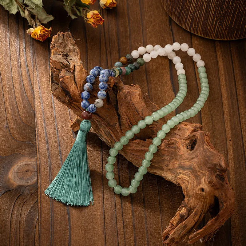 Bohemian-style long necklace chain with vintage tassel and matching bracelet on dark background