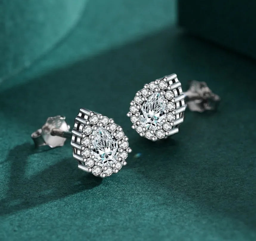 Close-up of women's sterling silver water drop shaped ear studs with diamond cut facets on a white background.