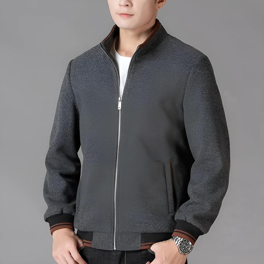 Man wearing a grey fleece sports jacket with a stick pocket on the chest.