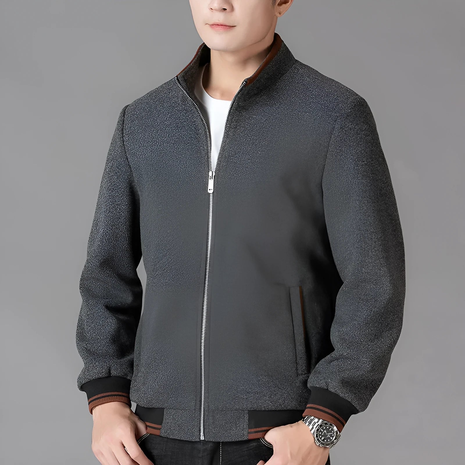 Man wearing a grey fleece sports jacket with a stick pocket on the chest.