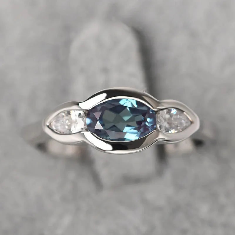 Geometric ellipse ring with inlaid zircon stones in white gold colour on female hand