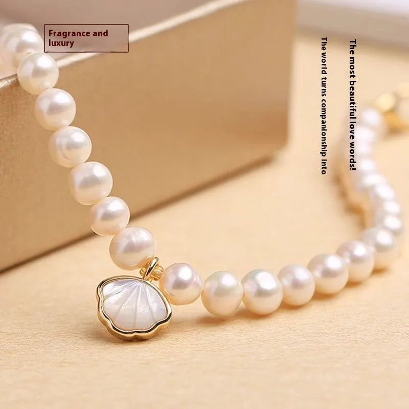 Women's freshwater pearl bracelet with fan-shaped alloy charm on a 16cm elastic string.