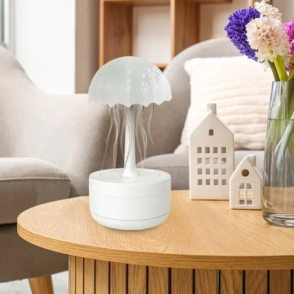 White jellyfish-shaped humidifier and essential oil diffuser with colourful LED lights on a desk.