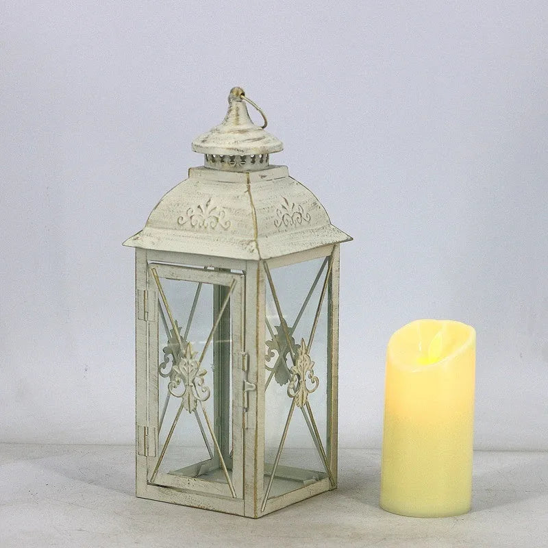 Black wrought iron floor lantern with tempered glass panels, standing on a patio.