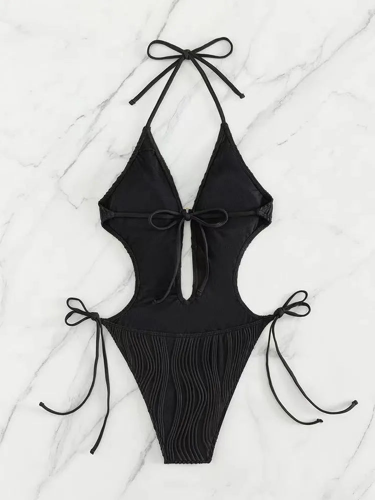 Women's black lace up triangle bikini swimsuit on solid colour background