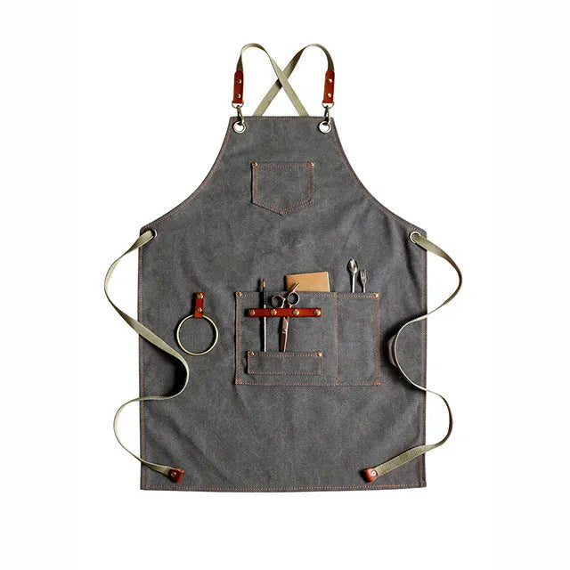 Canvas cross-back apron in camel colour on a mannequin, showing adjustable neck and waist ties