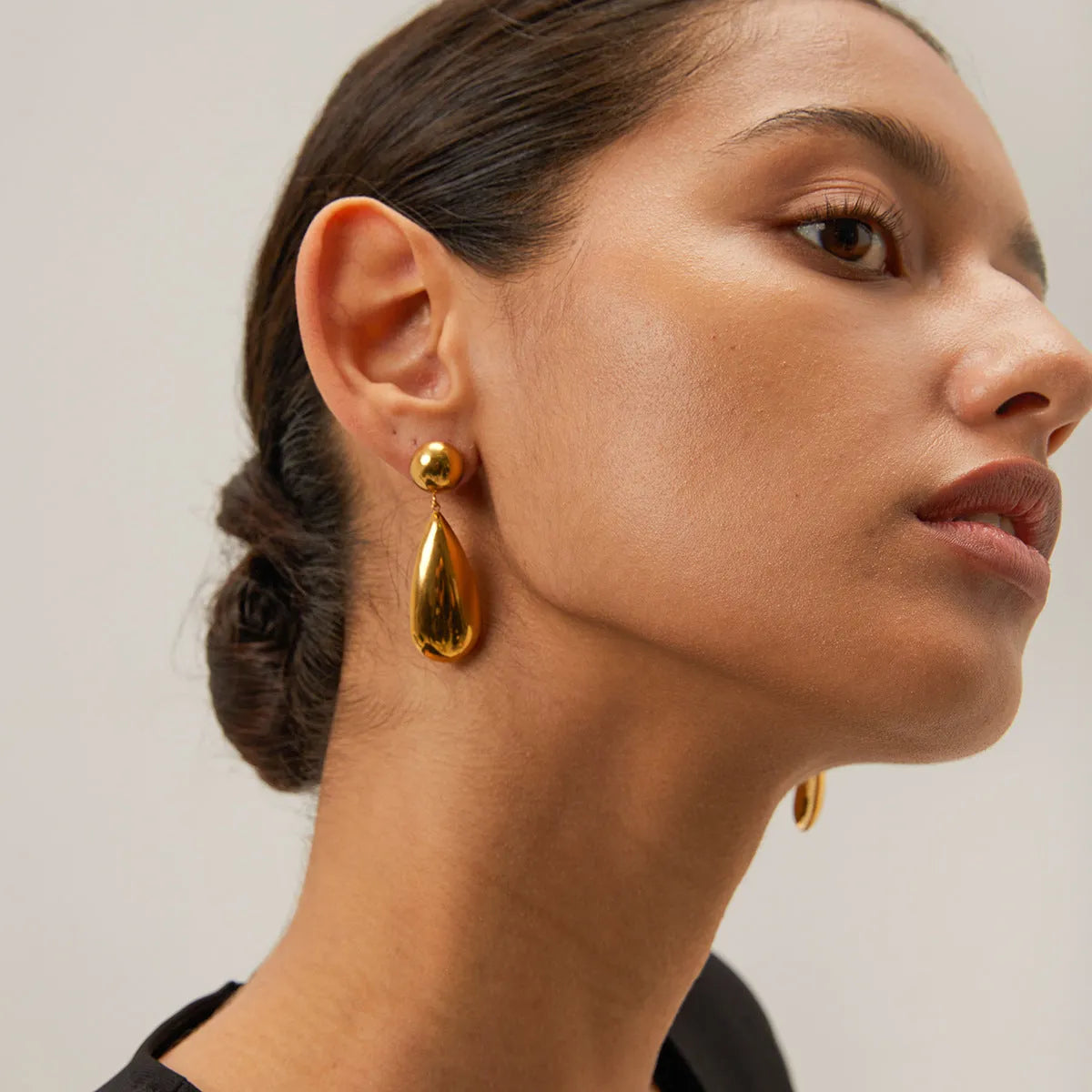 Gold coloured stainless steel earrings with geometric water drop hemisphere pendant design