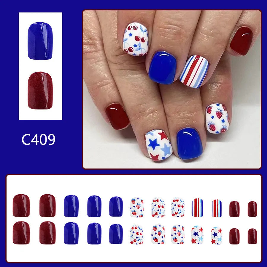 Short glossy false nails with strawberry cherry independence day patterns in red and blue