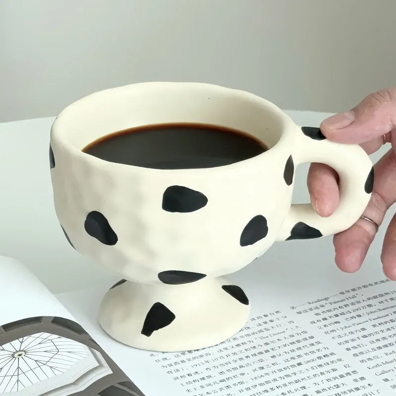 A hand-pinched irregular shaped ceramic mug in a solid colour, shown on a plain background.