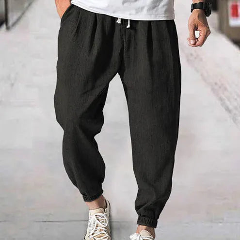 Men's casual cotton trousers with ankle bands in light green colour showing loose fit design