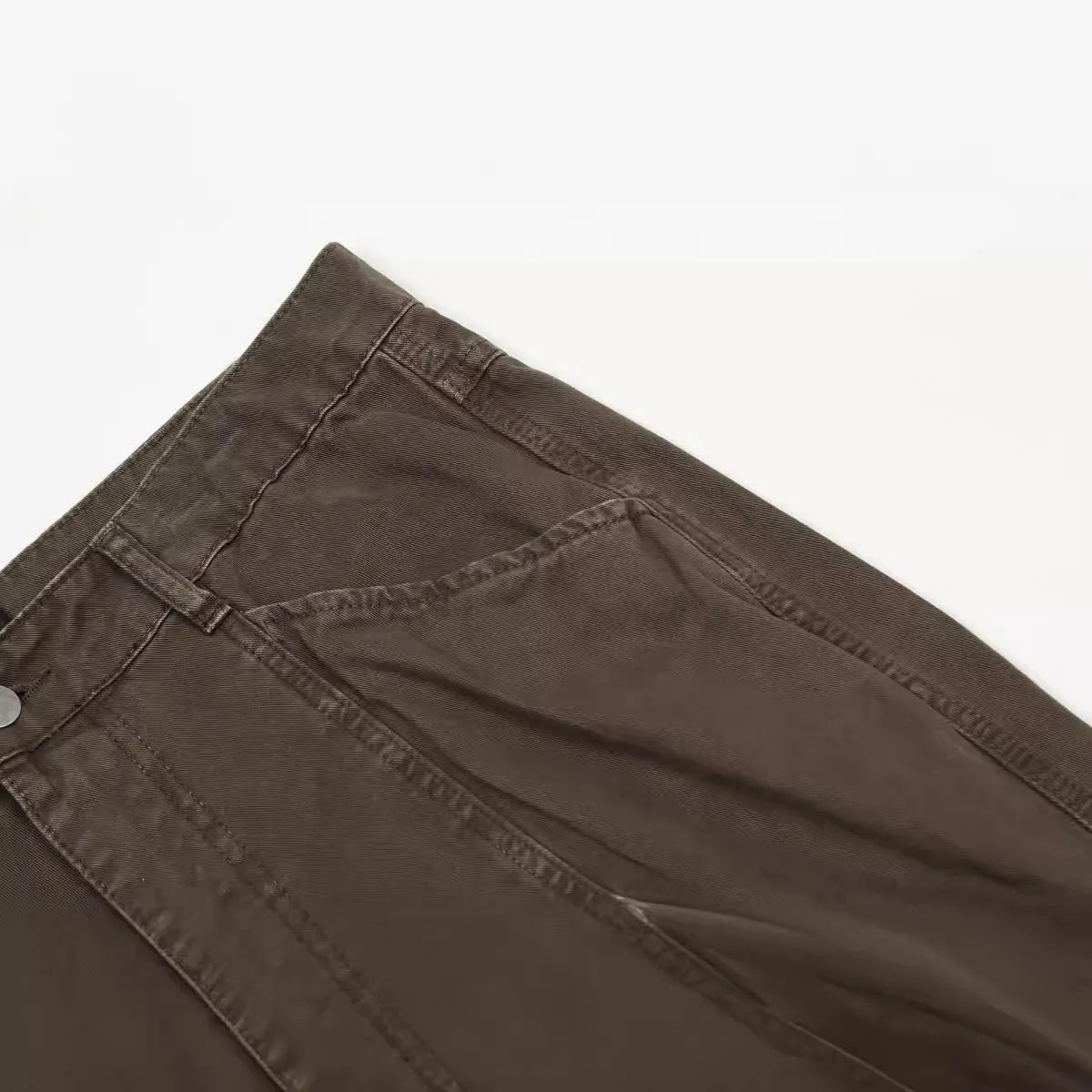 Men's brown loose fit straight leg cotton jeans with a high waist and zip fly on a hanger.