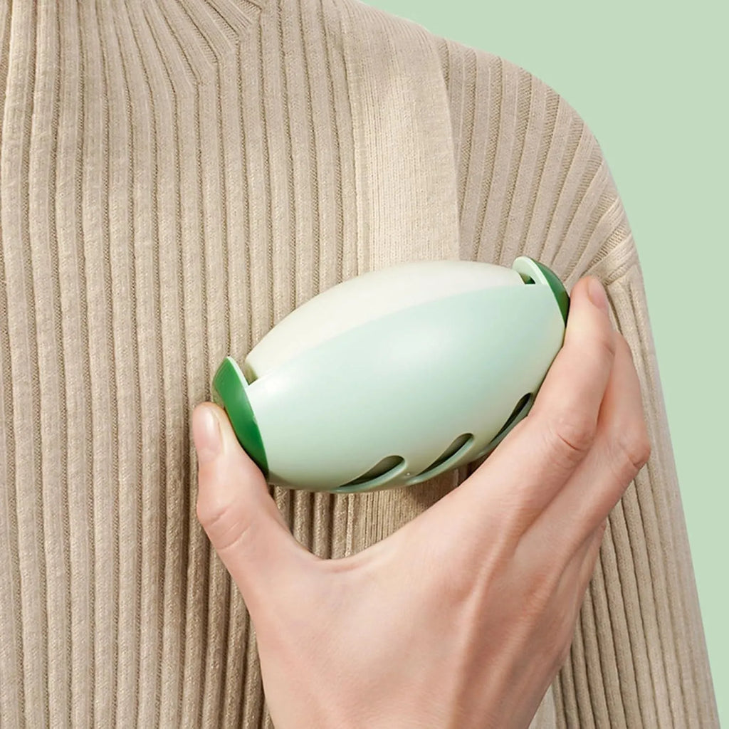 Green and white reusable gel lint roller ball for pet hair removal on fabric.