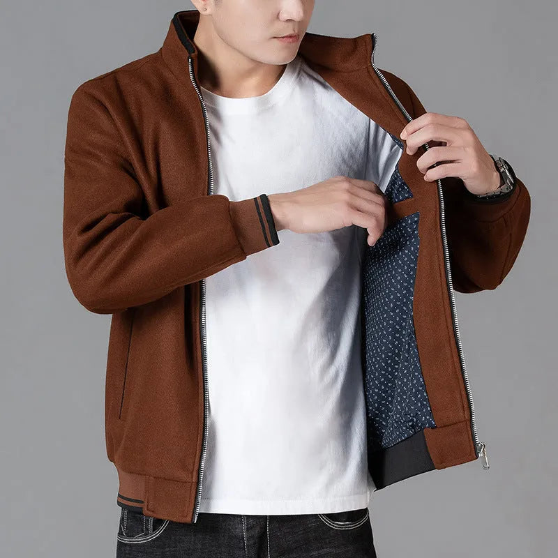 Man wearing a grey fleece sports jacket with a stick pocket on the chest.