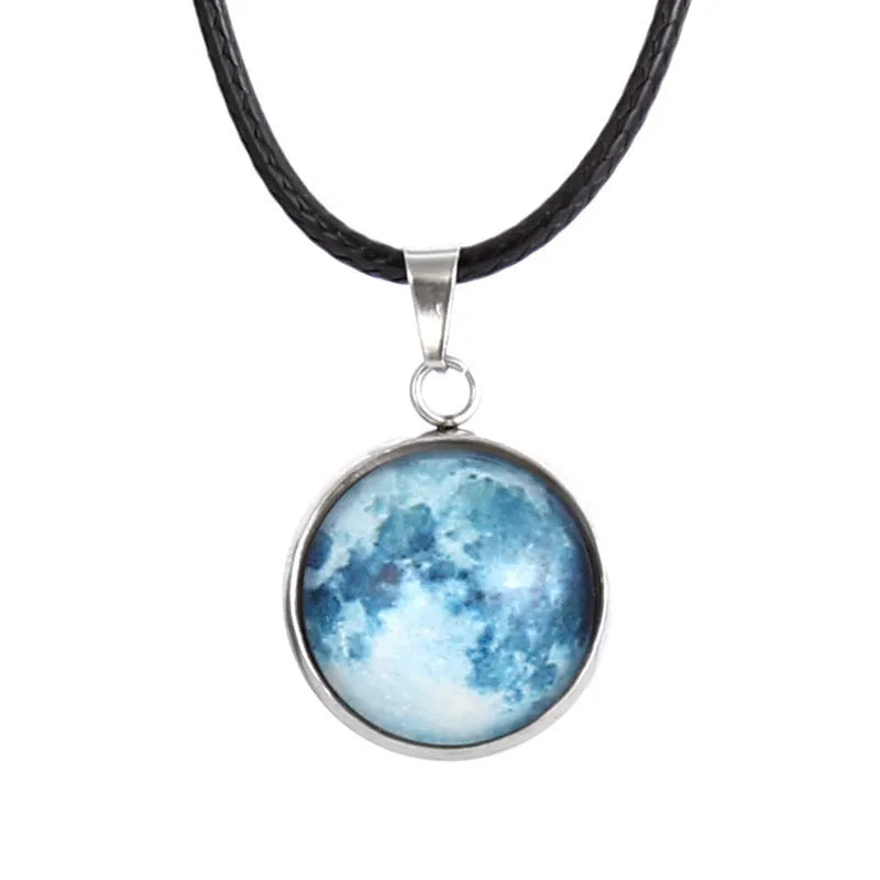 Close-up of a luminous alloy necklace with a blue organic glass constellation pendant on a model.