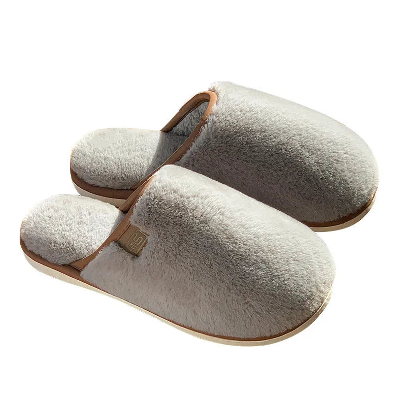 Solid-colour winter plush slippers with non-slip PVC sole on a home floor