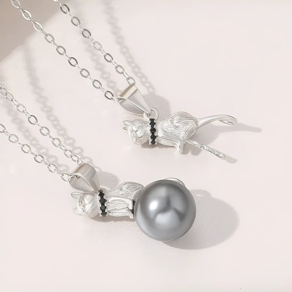 Close-up of a sterling silver cat pendant on a clavicle chain, showing detailed feline design and bright electroplated finish.