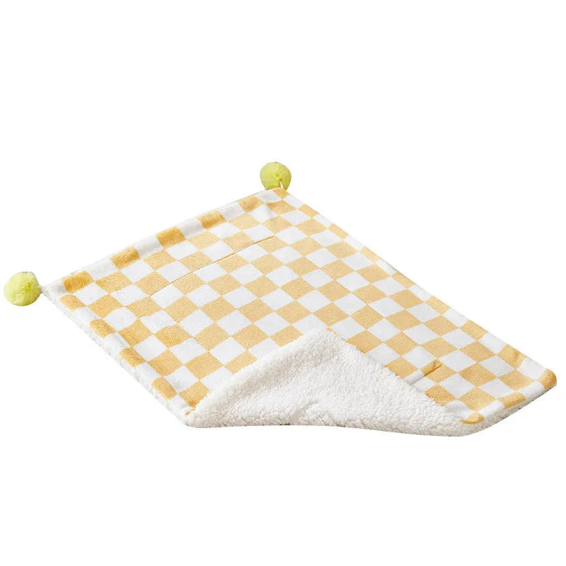 Green plaid pattern pet blanket with fur ball decoration on sofa