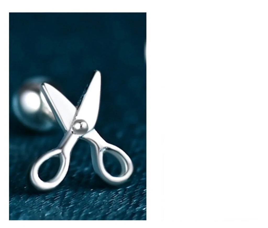 A pair of pure silver screw-back ear nails with a miniature scissors design.