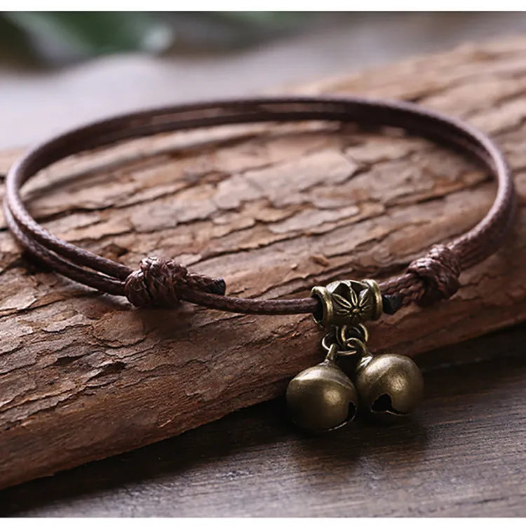 Small dog collar made of nylon rope with a brass bell, shown in black colour.
