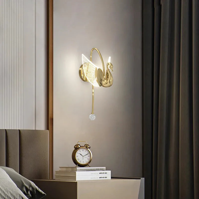 Gold modern swan wall lamp with acrylic shade mounted beside bed