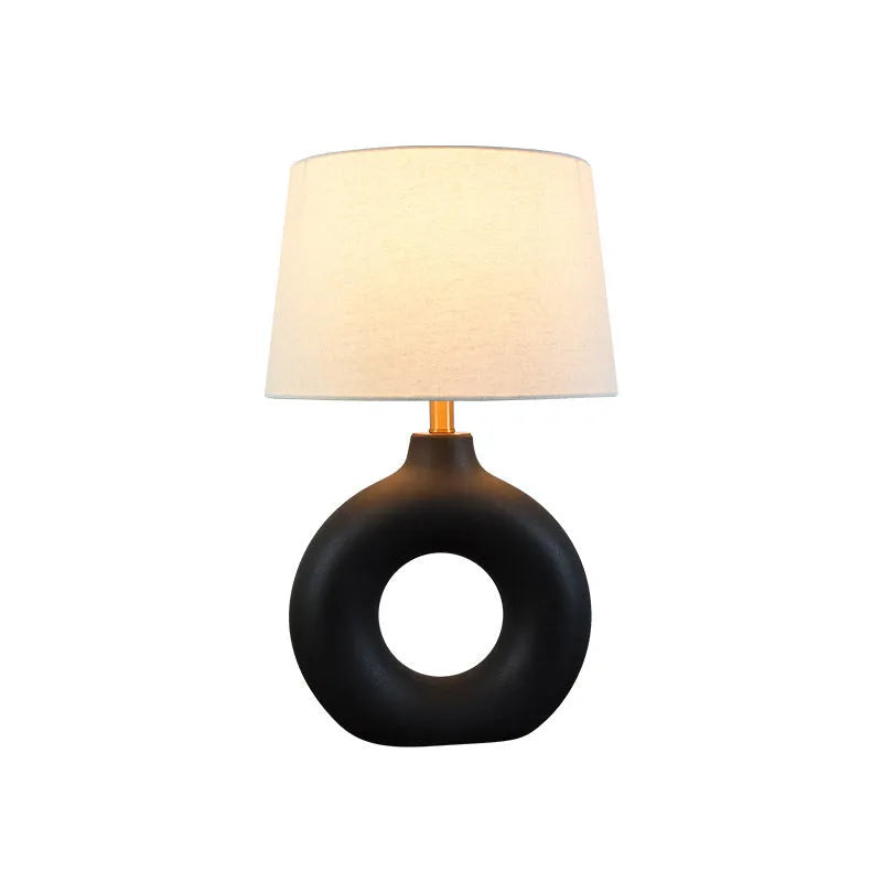 Small white Japanese style Feng Pottery Pot table lamp with ceramic base and fabric shade on a desk.