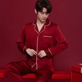 Red men's and women's long sleeve ice silk pyjama set laid flat.