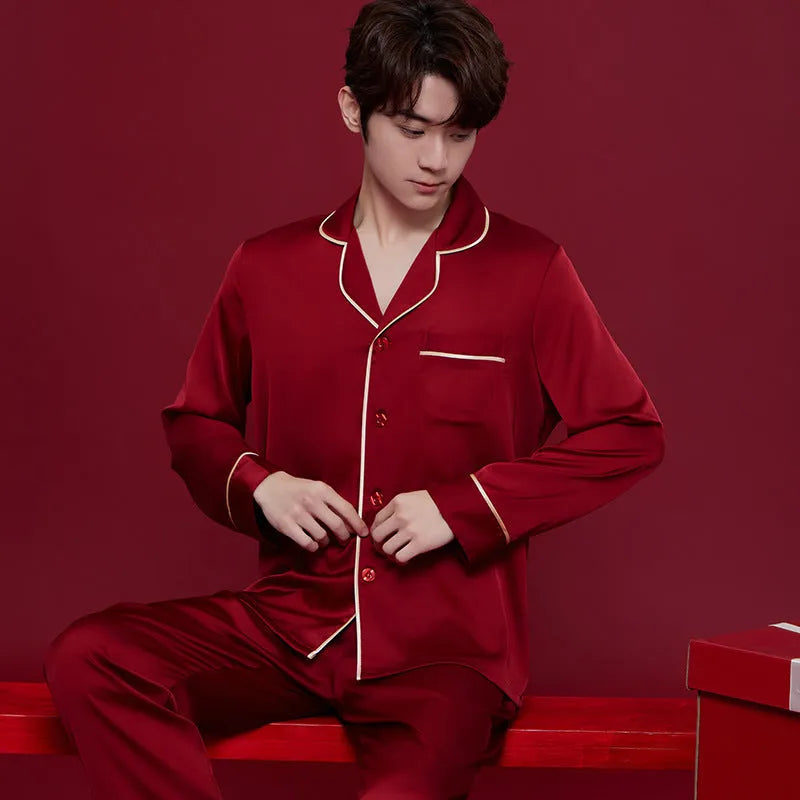 Red men's and women's long sleeve ice silk pyjama set laid flat.