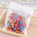 Assortment of 50 colourful miniature cartoon erasers including fruit, animal and theme designs.
