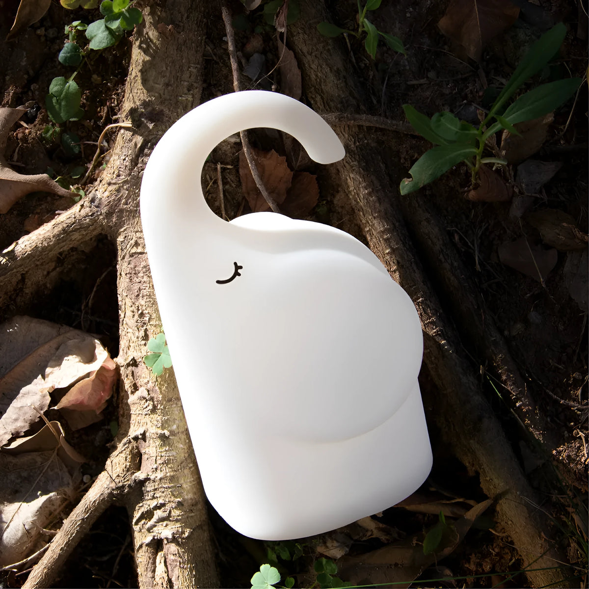DOMI Elephant-shaped silicone night light in white with warm LED glow on a bedside table.