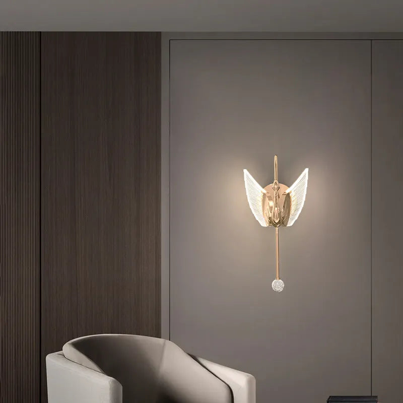 Gold modern swan wall lamp with acrylic shade mounted beside bed