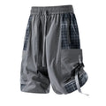 Man wearing loose-fit beige cargo shorts with visible plaid stitching detail on the legs.
