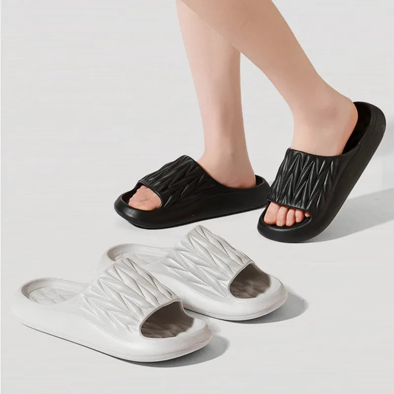 Pair of grey EVA foam slippers with leaf texture pattern and non-slip sole.