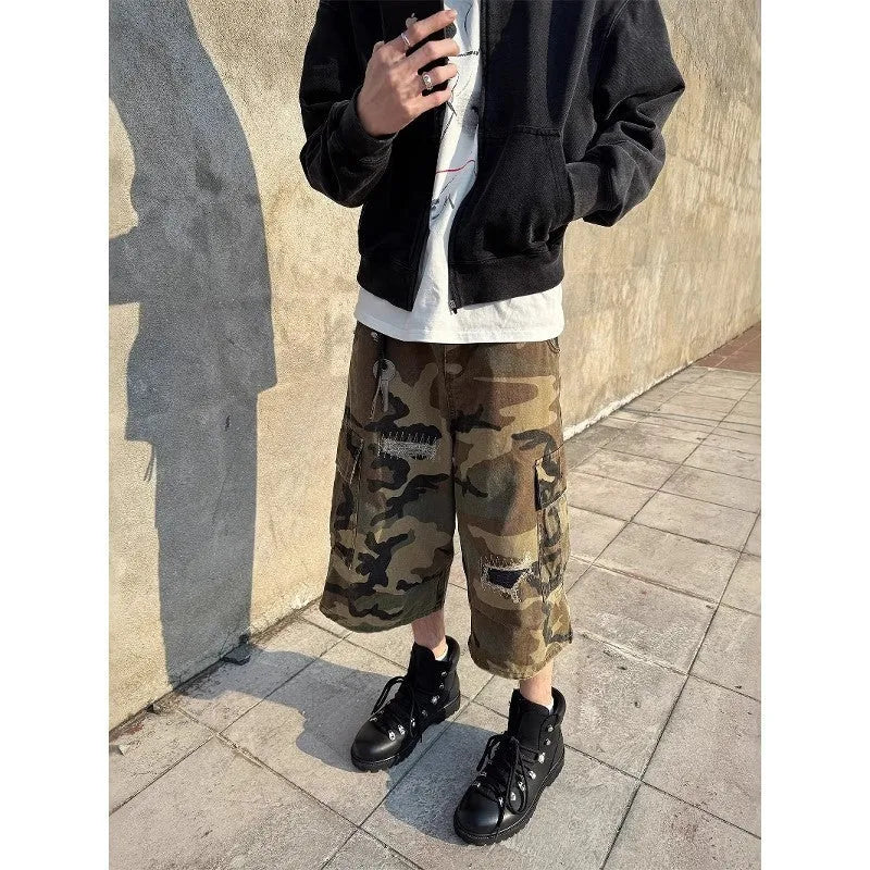 Men's camouflage-colour jeans with patch details, ripped fabric, and a cropped, loose straight-leg fit.
