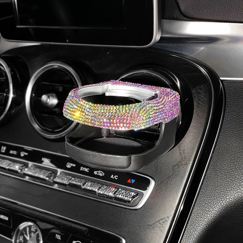 Sparkling rhinestone car cup holder bracket clipped to a vehicle air vent, shown in pink diamond colour.