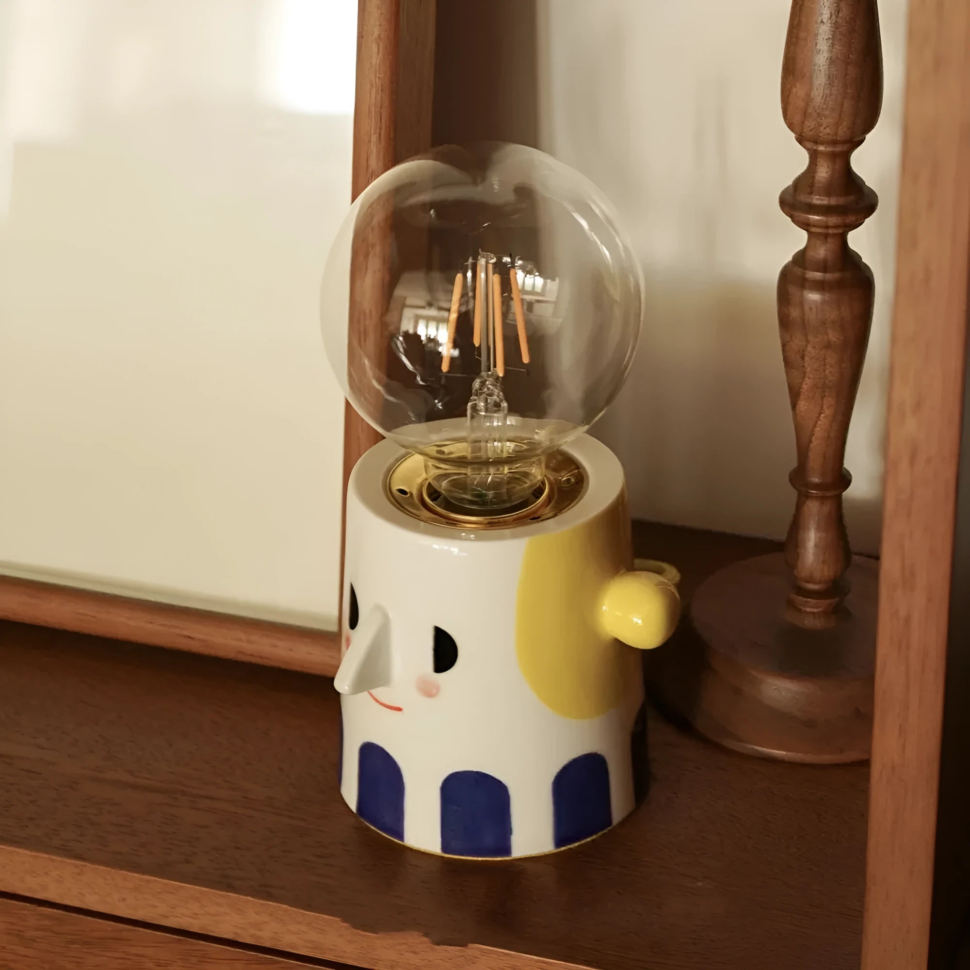 Handmade ceramic bedside lamp with spherical shade on wooden table