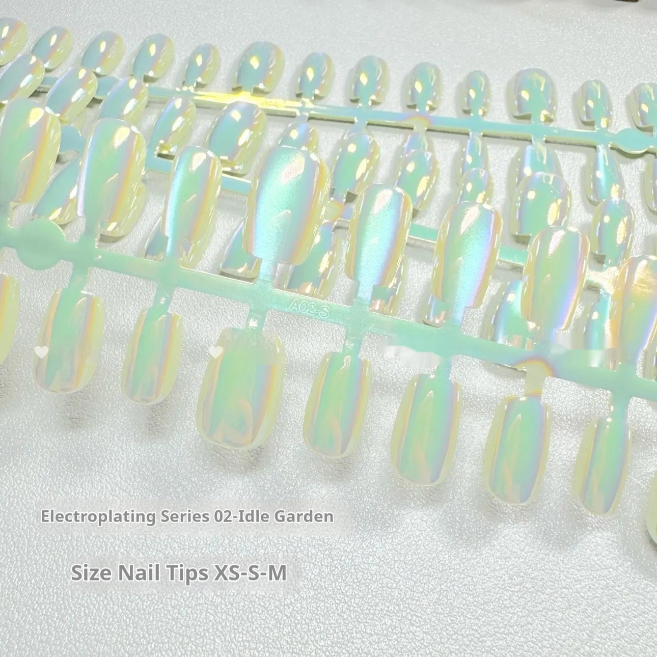 Cat's Eye electroplated false nails set with aurora glow in short ladder sizes on a hand.
