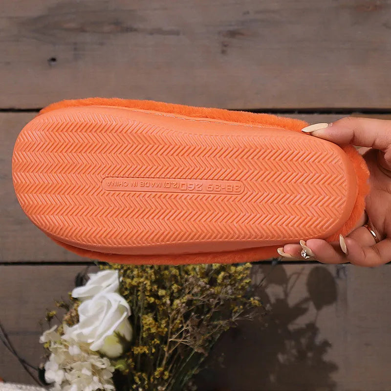 Orange Halloween pumpkin design plush slippers with a non-slip sole.