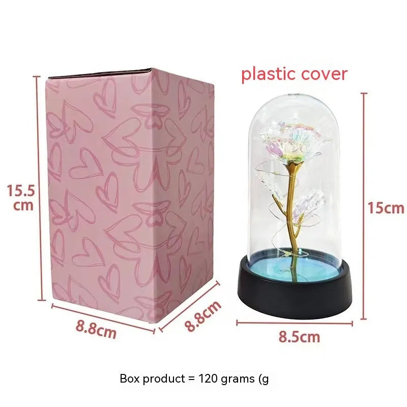 Small plastic night lamp with glass cover showing coloured flowers inside on black base