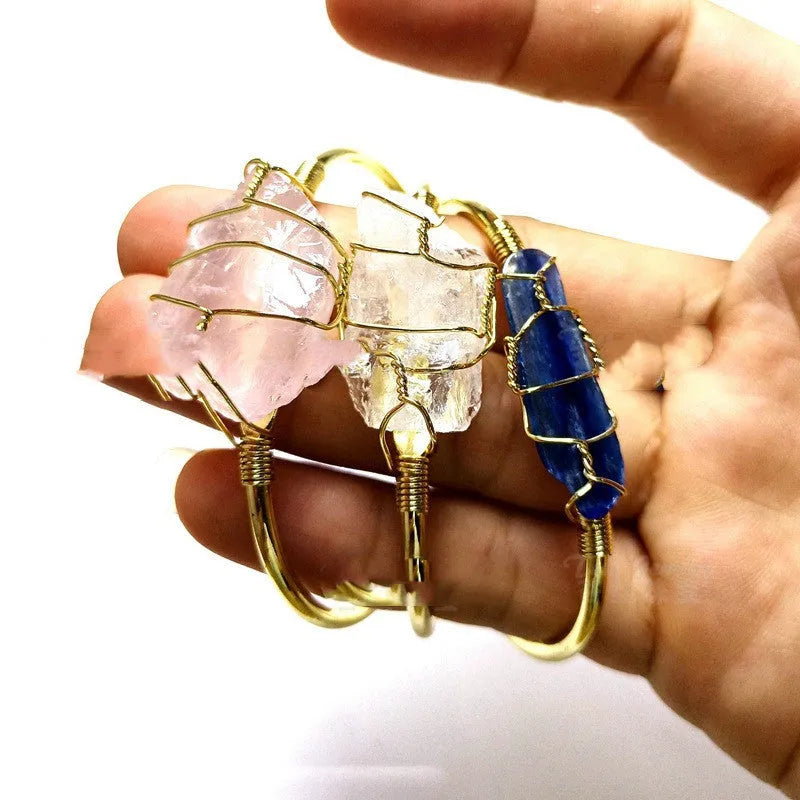 Unisex rough natural crystal bracelet with geometric gold metal winding on a wrist