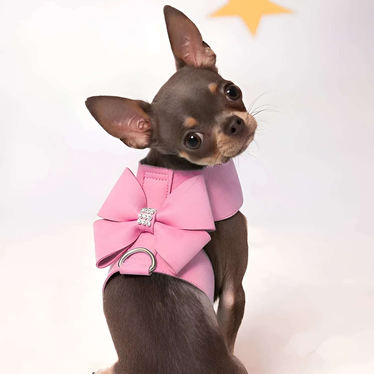 A pink microfiber dog chest strap featuring a sewn-on bowknot shaped like a puppy.