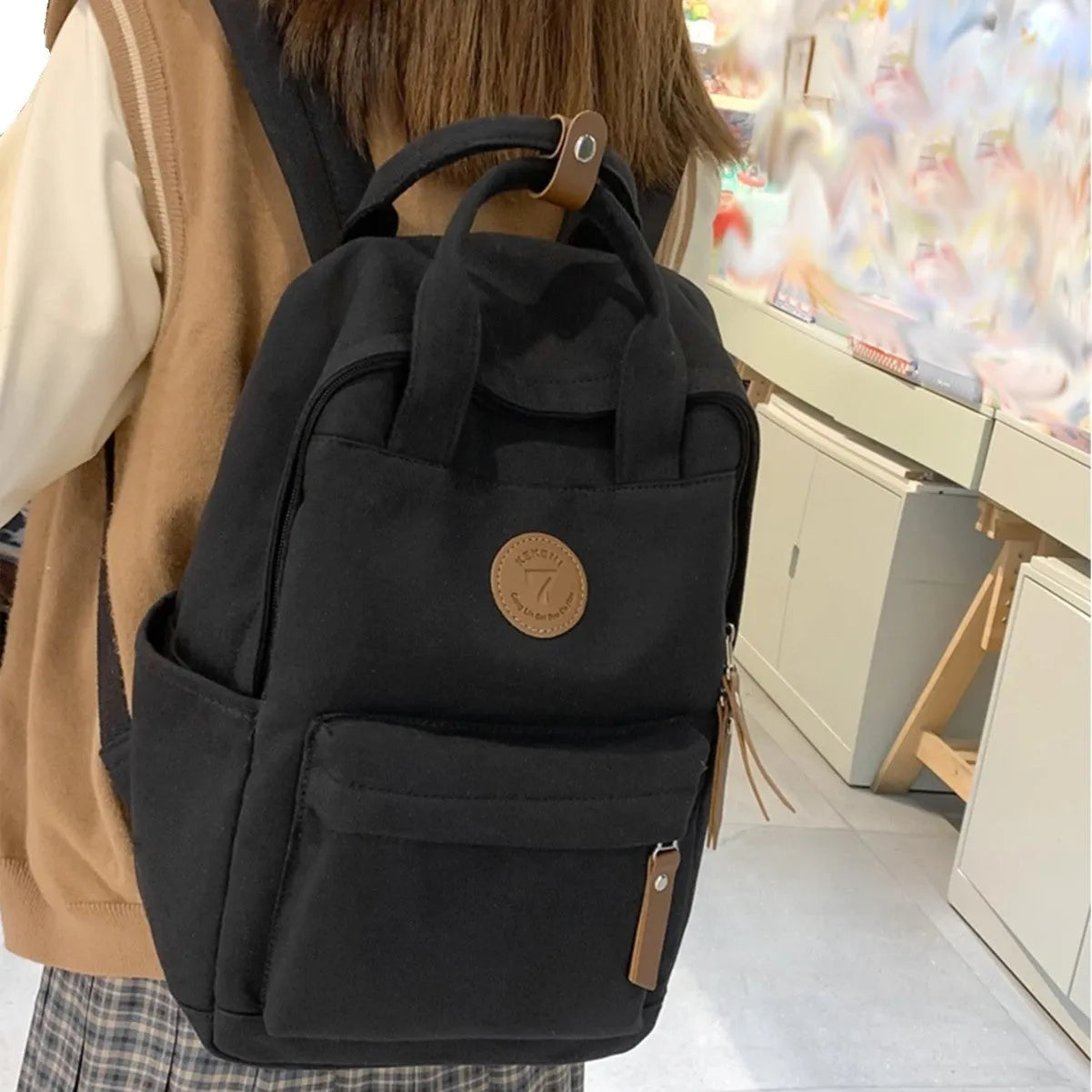 Black Oxford cloth leisure backpack with curved shoulder straps and retro sewing thread detailing