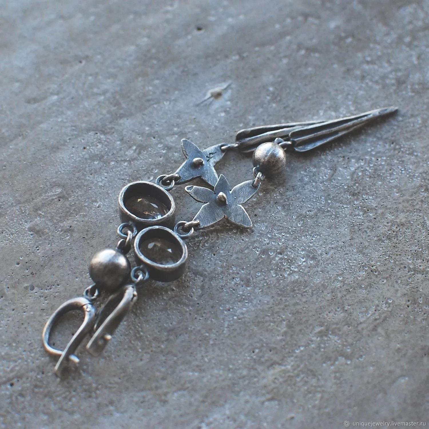 Geometric long pendant earrings with antique silver plating and rhinestone details on an XINGX design.