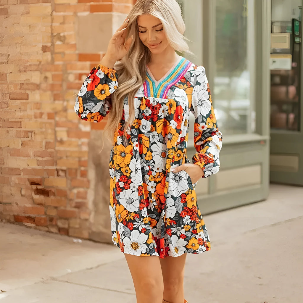 Orange floral print mini dress with striped lace detailing, V-neck, and long sleeves.