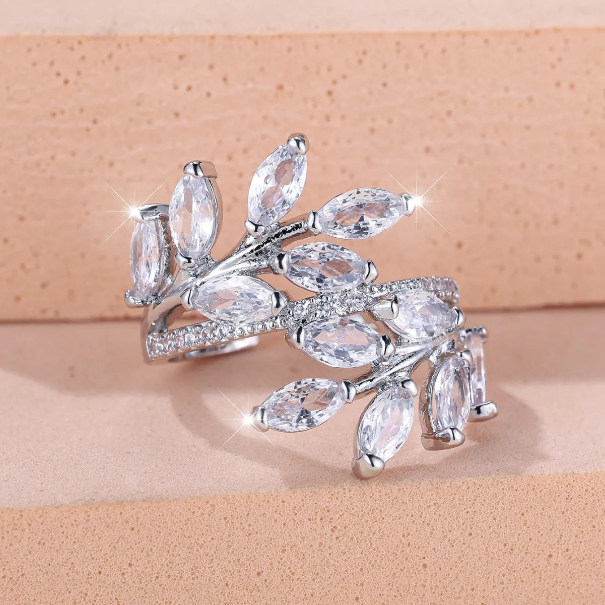 Adjustable opening copper leaf fashion ring with sparkling zirconia stones in a rose gold finish.